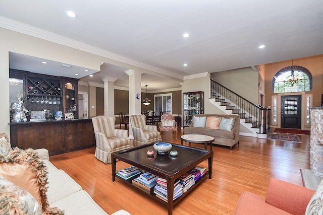 living area with stairway, recessed lighting, wood finished floors, and decorative columns