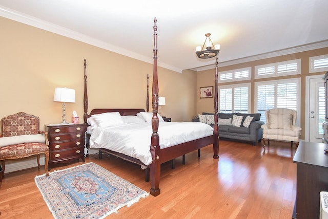 bedroom with wood finished floors and ornamental molding