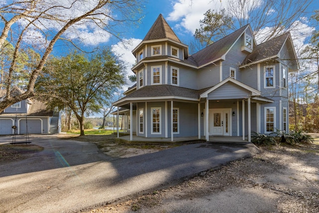 victorian house with driveway and a porch