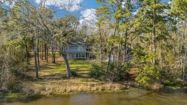 back of house featuring a yard and a water view