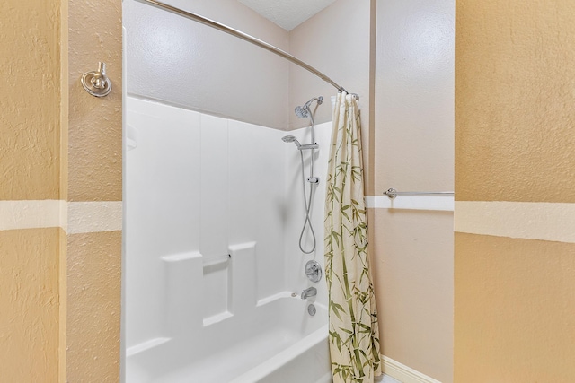 full bath with shower / tub combo with curtain and a textured wall