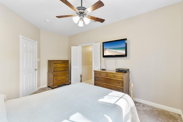 carpeted bedroom with ceiling fan and baseboards