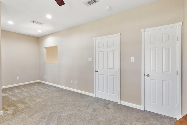 unfurnished room featuring carpet floors, ceiling fan, visible vents, and baseboards