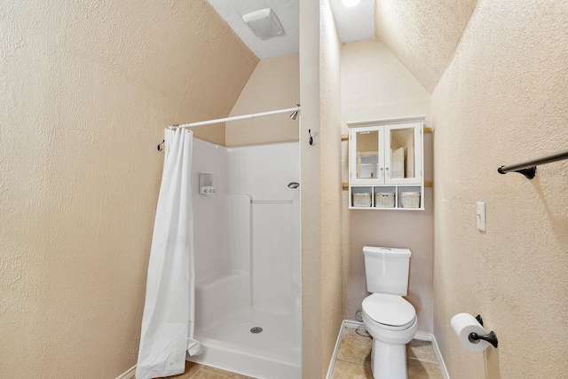 full bathroom with a textured wall, toilet, tile patterned flooring, vaulted ceiling, and a shower stall