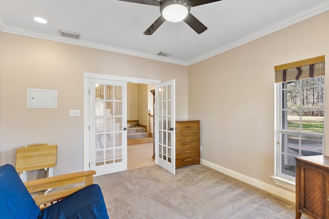 living area with carpet floors, a healthy amount of sunlight, and crown molding