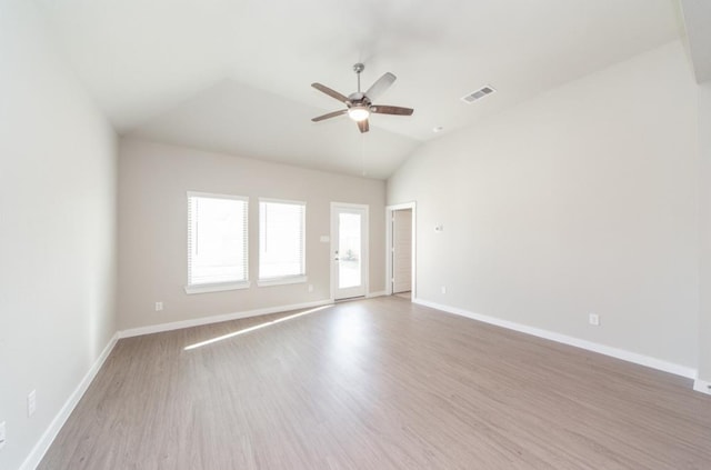 spare room featuring visible vents, ceiling fan, vaulted ceiling, wood finished floors, and baseboards