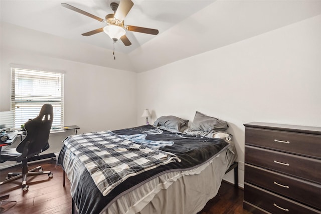 bedroom featuring dark wood-type flooring, vaulted ceiling, and ceiling fan