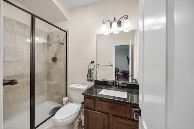 full bathroom featuring a stall shower, vanity, and toilet