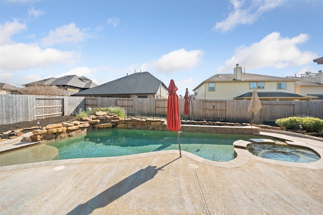 view of swimming pool with a fenced backyard, a pool with connected hot tub, and a patio