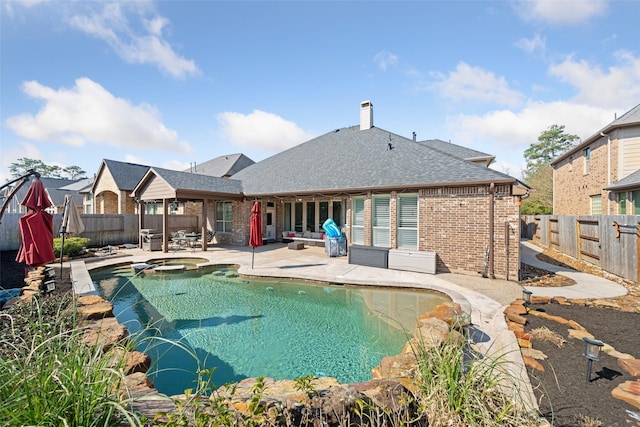 view of swimming pool with a patio area, a fenced backyard, and a pool with connected hot tub