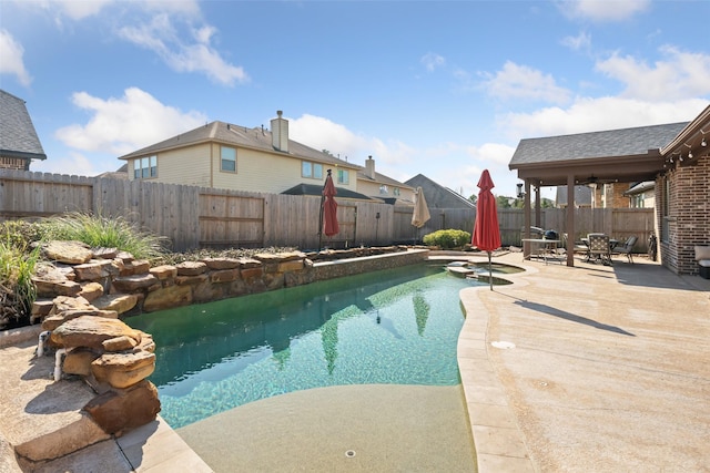 view of pool featuring a pool with connected hot tub, a fenced backyard, and a patio