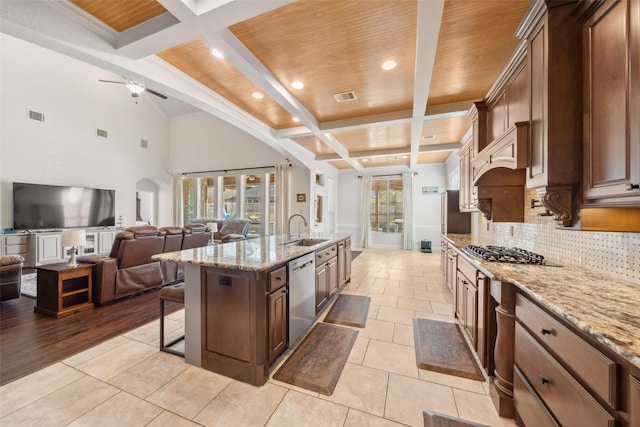 kitchen featuring stainless steel appliances, a sink, visible vents, a kitchen breakfast bar, and tasteful backsplash