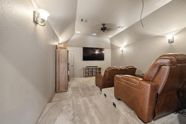 cinema featuring lofted ceiling, visible vents, ceiling fan, and light carpet