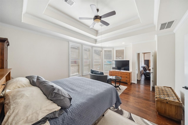 bedroom featuring dark wood-type flooring, a raised ceiling, and visible vents