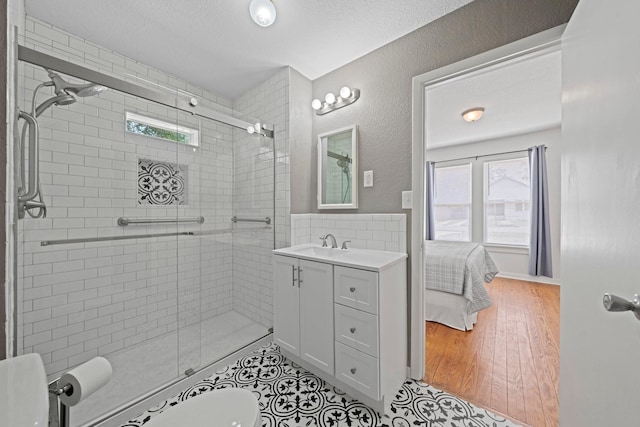 bathroom with a textured ceiling, a stall shower, and a wealth of natural light