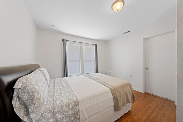 bedroom with visible vents and wood finished floors