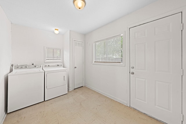 washroom with laundry area, visible vents, baseboards, light floors, and washing machine and clothes dryer