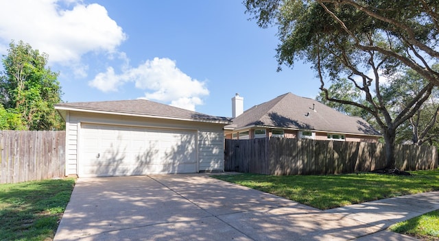 view of home's exterior featuring an outbuilding, a lawn, a detached garage, and fence