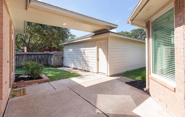 view of patio featuring an outbuilding and fence