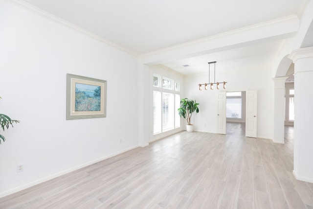 empty room featuring arched walkways, light wood finished floors, ornamental molding, and decorative columns