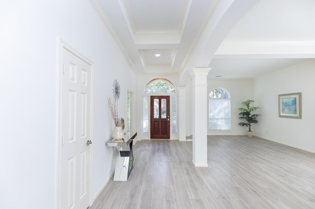 entrance foyer with decorative columns, arched walkways, light wood-style flooring, and crown molding