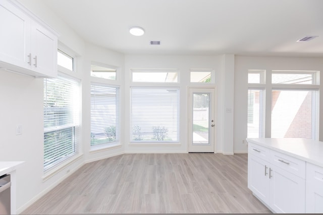 interior space with light wood-type flooring, visible vents, and baseboards