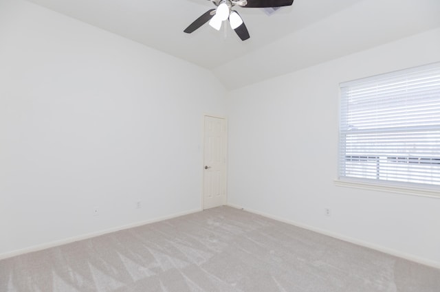 unfurnished room featuring light carpet, lofted ceiling, a ceiling fan, and baseboards