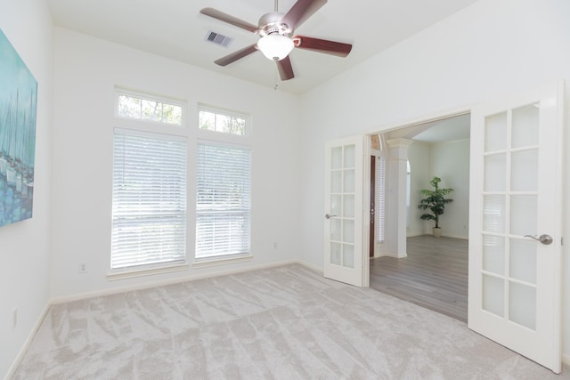 carpeted empty room with french doors, plenty of natural light, visible vents, and a ceiling fan