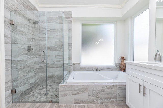 full bathroom featuring a bath, a stall shower, crown molding, and vanity