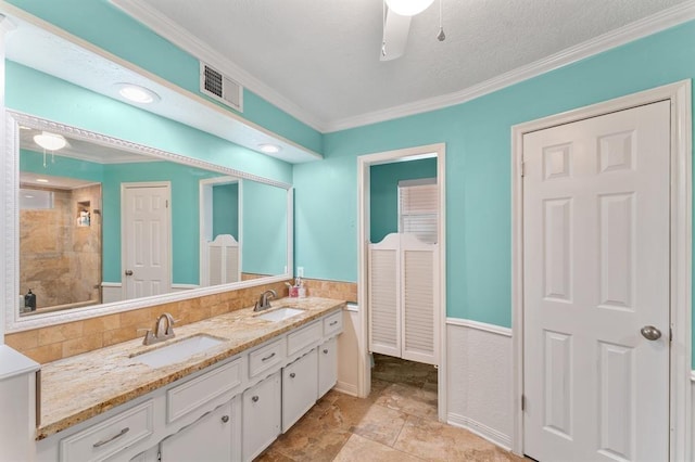 full bathroom featuring crown molding, visible vents, a sink, and a shower stall