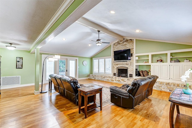 living area featuring vaulted ceiling with beams, light wood finished floors, a fireplace, and visible vents