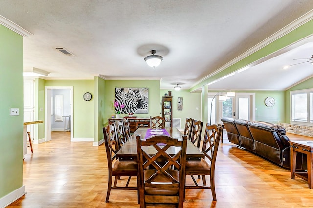 dining space with light wood-type flooring, visible vents, french doors, and ornamental molding