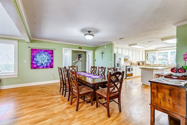 dining room featuring light wood-style floors, visible vents, and crown molding