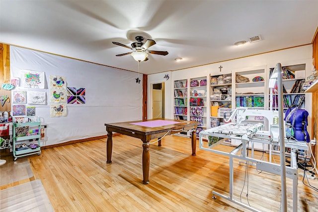 home office with light wood-style floors, visible vents, baseboards, and a ceiling fan