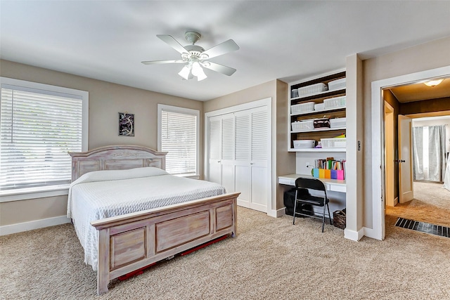 bedroom featuring baseboards, multiple windows, a closet, and light colored carpet