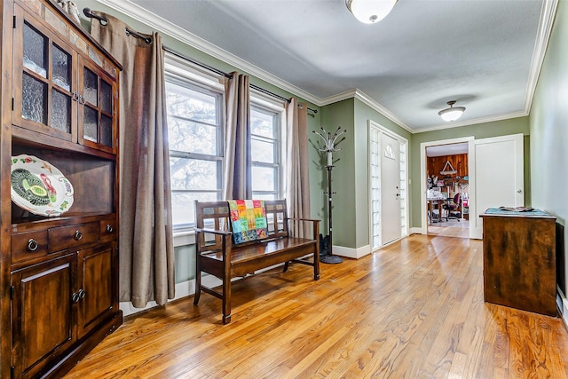 foyer featuring ornamental molding, light wood-style flooring, and baseboards