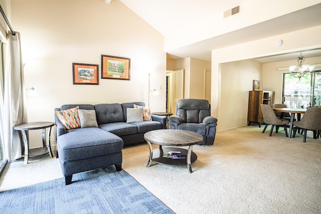 carpeted living area featuring high vaulted ceiling, visible vents, and an inviting chandelier