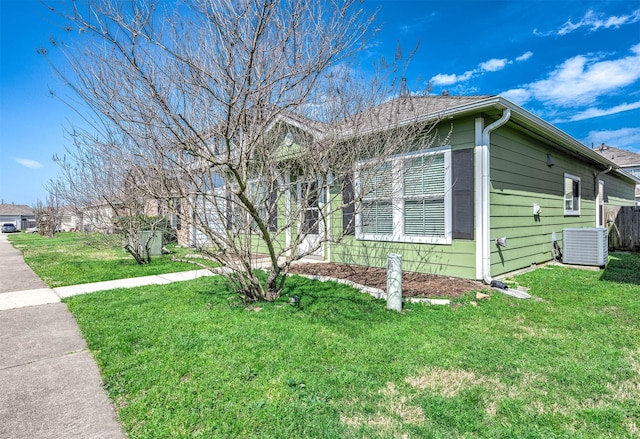 view of front of property with a front yard and central air condition unit