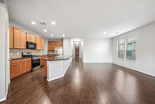 kitchen featuring visible vents, dark wood finished floors, dark countertops, stainless steel appliances, and backsplash