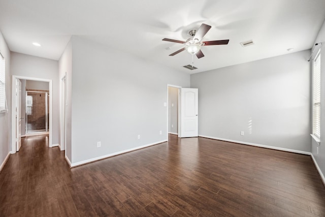 interior space featuring ceiling fan, dark wood finished floors, visible vents, and baseboards