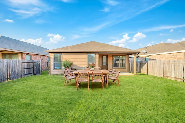 back of house with a yard and a fenced backyard