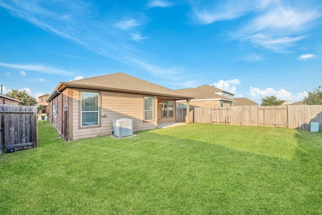 back of property with a fenced backyard, a lawn, and cooling unit