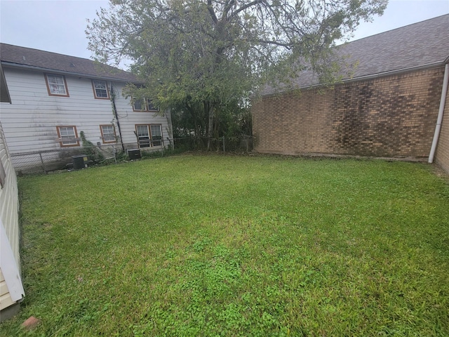 view of yard with fence and central air condition unit