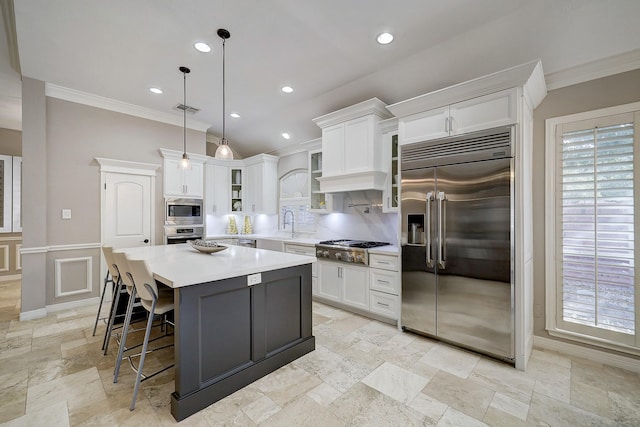 kitchen featuring built in appliances, crown molding, and white cabinets