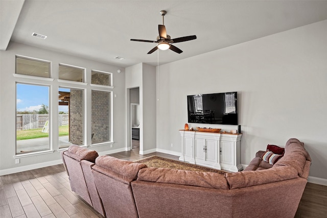 living room featuring ceiling fan, wood finished floors, visible vents, and baseboards