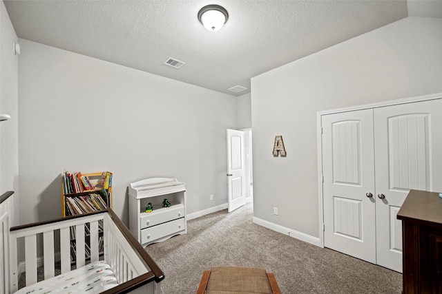 bedroom featuring carpet floors, lofted ceiling, visible vents, a textured ceiling, and baseboards