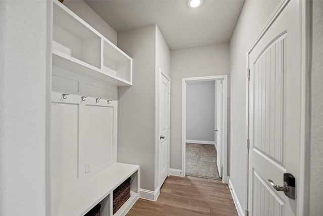 mudroom featuring wood finished floors and baseboards