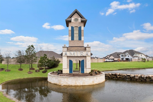 surrounding community featuring a lawn and a water view