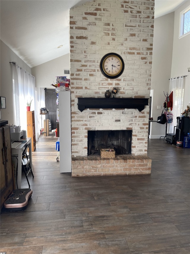 living area featuring high vaulted ceiling, a brick fireplace, wood finished floors, and visible vents