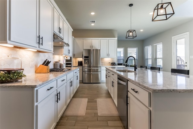 kitchen with visible vents, appliances with stainless steel finishes, under cabinet range hood, white cabinetry, and a sink